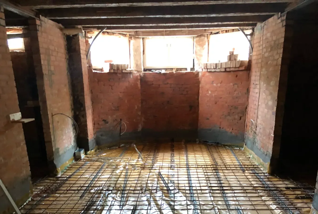 Kælder før totalrenovering – rå murstensvægge og nyt gulv under opbygning, Helsingør